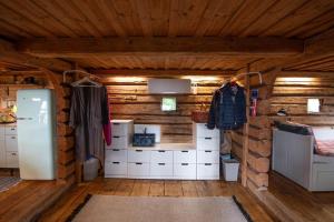 a room with wooden walls and white cabinets and a refrigerator at Getaway in the wilderness in Hämeenlinna +21 photos