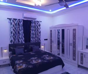 a bedroom with a king sized bed and a dresser at Perry Hills Apartment in Tokuse