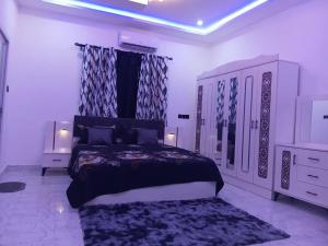 a bedroom with a king sized bed and a dresser at Perry Hills Apartment in Tokuse