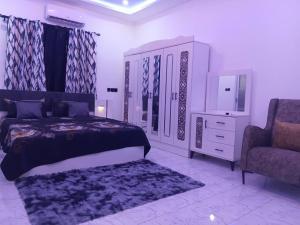 a bedroom with a bed and a chair and a dresser at Perry Hills Apartment in Tokuse