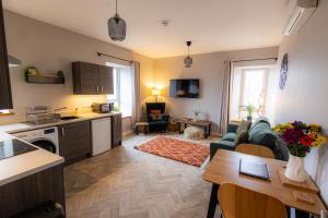 a kitchen and living room with a couch and a table at Bignold Park View in Orkney