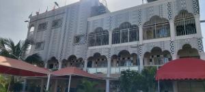 a large white building with a lot of windows at Sweet Mama in Bijilo