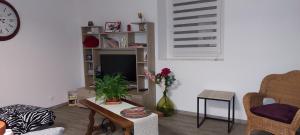 a living room with a vase of flowers on a table at Agréable T2 50m2 in Aubin