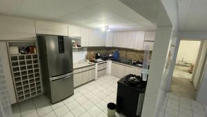 a kitchen with white cabinets and a stainless steel refrigerator at Casa Carnaval Olinda 2026 in Recife