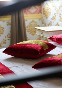 two red pillows sitting on top of a bed at Jessica Flat Malta Royal Guesthouse in Cospicua