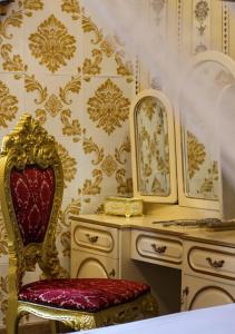 a room with a red chair and a dressing table at Jessica Flat Malta Royal Guesthouse in Cospicua