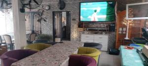 a dining room table with chairs and a television at Sweet Mama in Bijilo