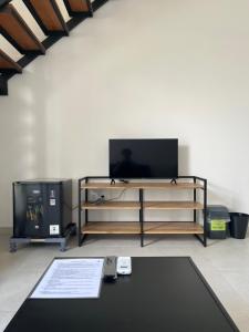 a living room with a tv and a table at Naung CoLiving in Kerobokan