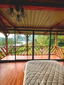 a bedroom with a large bed on a wooden deck at Finca Milele in Macanal