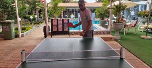 a man playing ping pong on a ping pong table at Sweet Mama in Bijilo +10 photos