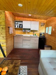 a kitchen with wooden walls and a couch in a room at Finca Milele in Macanal +12 photos