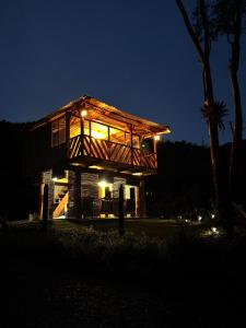 a house with lights on it at night at Finca Milele in Macanal
