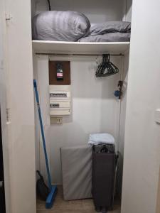 a bedroom with a bed and a mop in a room at La Douce Escale studio in Courseulles-sur-Mer