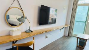 a room with a mirror and a tv on a wall at 小逗民宿 in Taitung City