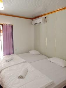 two twin beds in a small room with a window at Jambu Tree Homestay in Tanjungjati