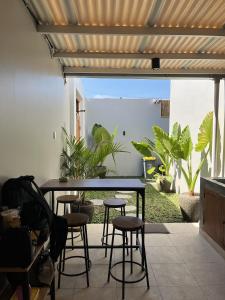 a table and stools in a room with plants at Naung CoLiving in Kerobokan