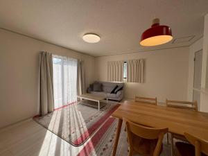 a living room with a table and a couch at 青梅森の宿3号館新築一棟貸し東青梅駅徒歩3分最大11人 in Ome