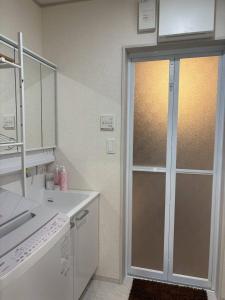 a white kitchen with a sliding glass door at 青梅森の宿3号館新築一棟貸し東青梅駅徒歩3分最大11人 in Ome +34 photos