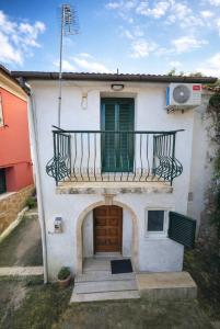 a small white house with a balcony and a door at Kathryns apartment in Sinarádes