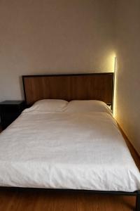 a bed with white sheets and a wooden headboard at Kathryns apartment in Sinarádes +5 photos