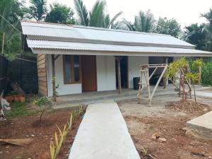 a small house with a walkway in front of it at Jambu Tree Homestay in Tanjungjati