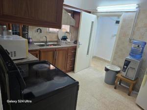 a kitchen with a stove and a sink and a refrigerator at B Beitna in Amman +46 photos
