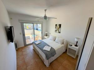 a bedroom with a bed and a ceiling fan at Duna 6 in Mar de las Pampas +64 photos