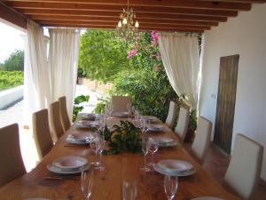 a long wooden table with wine glasses on it at Morna valley in Sant Carles de Peralta
