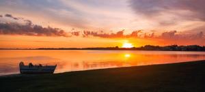 a boat on the shore of a lake at sunset at Refúgio da Lagoa de Araruama - AP 202 in Araruama