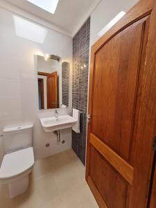 a bathroom with a toilet and a sink and a door at Morna valley in Sant Carles de Peralta +22 photos