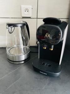 a black blender sitting on a counter next to a mixer at L entre deux charentes in Montils