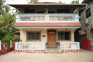 a brick house with a white fence in front of it at Swayam Beach Nivas in Srīvardhan