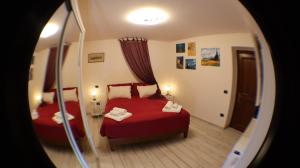 a bedroom with a red bed and a mirror at Rosari Spada Suite sec XVI in Spoleto