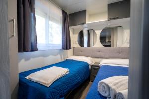 a small room with two beds and a mirror at Camping&Village Le Cernie in Lotzorai +38 photos