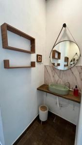 a bathroom with a sink and a mirror at Complexo Luquinha in Delfinópolis