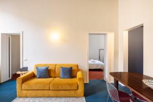 a living room with a yellow couch and a table at Dal Cardinale in Novara