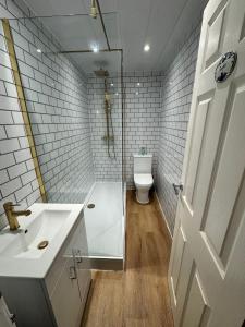 a bathroom with a toilet and a sink and a door at The Lang Toun Bothy - close to Edinburgh by Urban Haggis Stays in Kirkcaldy +35 photos