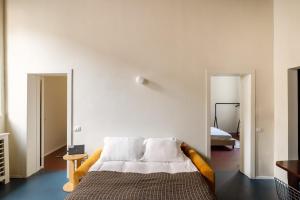 a bedroom with a bed with white walls at Dal Cardinale in Novara