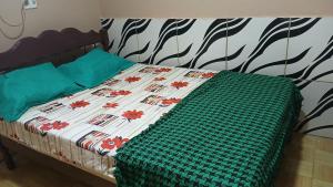 a bed with a green and white quilt on it at Varandas do mar II in Abade