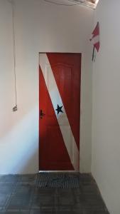 a red door with a flag painted on the side of a wall at Varandas do mar II in Abade