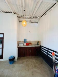 an empty room with a kitchen and aendant light at Lagoon Home Stay in Ahangama