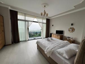 a bedroom with a bed and a large window at Çolakoğlu konağı in Cayeli