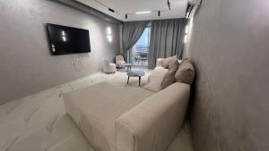 a living room with a couch and a tv on a wall at كورنيش نيل معادي in Al Ma‘şarah