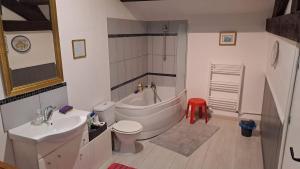 a bathroom with a tub and a toilet and a sink at Maison Saint Romain in Saulgond +17 photos