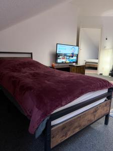 a bedroom with a bed and a flat screen tv at Gemütliches City-Appartment in Wentorf bei Hamburg