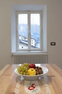 a bowl of fruit on a table with a window at La bottega del sarto in Grumes