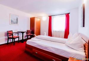 a bedroom with a bed and a table and a window at Pensiunea Vacanta in Lupeni