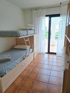a room with two bunk beds and a tiled floor at Les Oliveres Beach in Perelló +14 photos