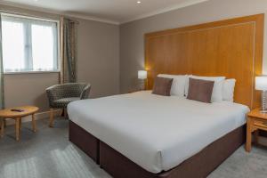 a hotel room with a large bed and a chair at Kings Court Hotel Alcester, BW Signature Collection in Stratford-upon-Avon +39 photos