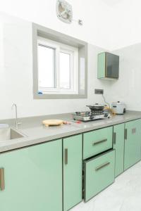 a kitchen with blue cabinets and a sink at Aikya Service Apartment in Hyderabad +7 photos